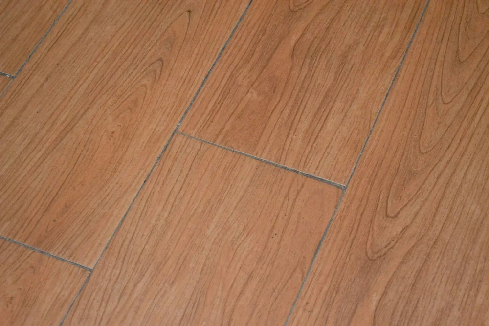 Close-up photo of wooden laminate flooring with rectangular planks arranged in a staggered pattern